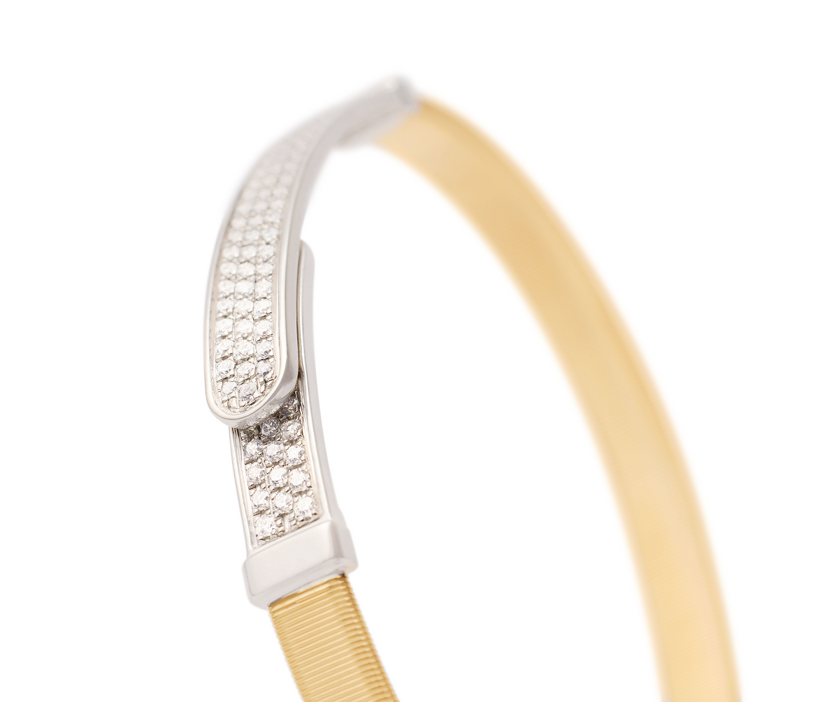 Sophisticated and linear in design, this bangle in 18K yellow gold is carefully handcrafted with the brand's exclusive coil technique and embellished with diamond pavé to add a dazzling touch of radiance to the wrist. Perfect on its own and stunning stacked with the other bangles in the collection, it is super easy to slip on and off thanks to the new integrated clasp.