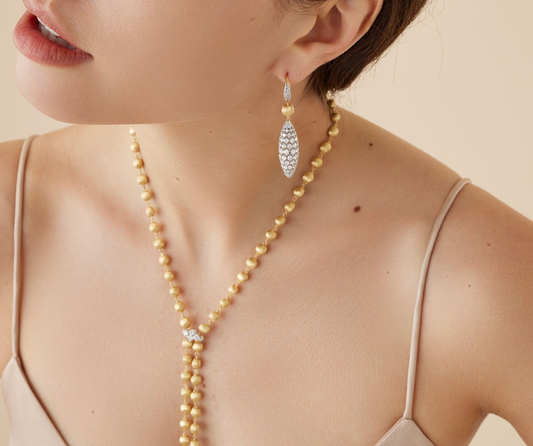 Sophisticated drop earrings featuring an 18k yellow gold bead, finely hand-engraved using the ancient Florentine technique and an eye-catching oval shape pavé-set diamond elements, suspended from graceful pavé clips. Already a classic.