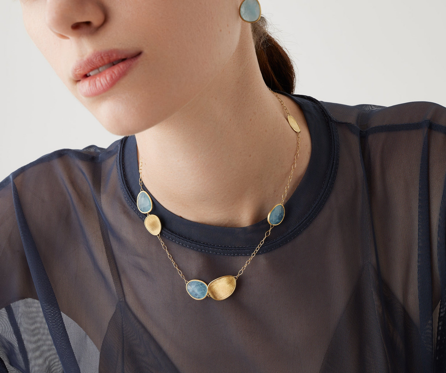 Inspired by the charm of nature, this delicate necklace features a sequence of light leaves in 18K yellow gold, finely hand-engraved using the ancient Florentine technique and interspersed with a thin chain. It is further embellished with leaf-shaped blue aquamarine stones, to add a touch of color to your outfit. Adjustable chain.