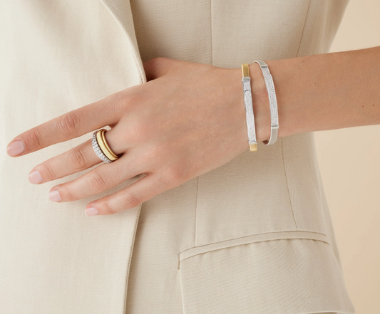 Sophisticated and linear in design, this bangle in 18K yellow gold is carefully handcrafted with the brand's exclusive coil technique and embellished with diamond pavé to add a dazzling touch of radiance to the wrist. Perfect on its own and stunning stacked with the other bangles in the collection, it is super easy to slip on and off thanks to the new integrated clasp.