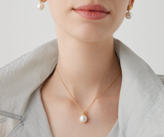 This 18K yellow gold and pearl pendant necklace is a timeless classic. The delicately elongated gold bail is hand-engraved using an ancient Florentine technique. The adjustable length provides the perfect fit and endless possibilities for any neckline, outfit, or occasion.