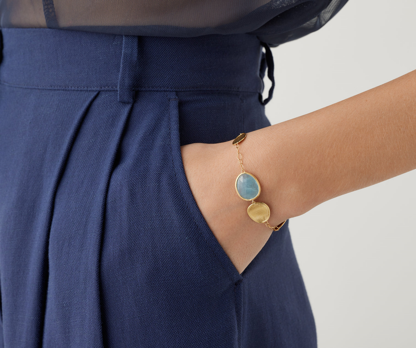 Delicate and chic, this 18k yellow gold bracelet combines light gold leaves with a natural leaf-shaped aquamarine stone, for a touch of color. Perfect for everyday wear, it is finely hand-engraved using the ancient Florentine technique. Adjustable chain.