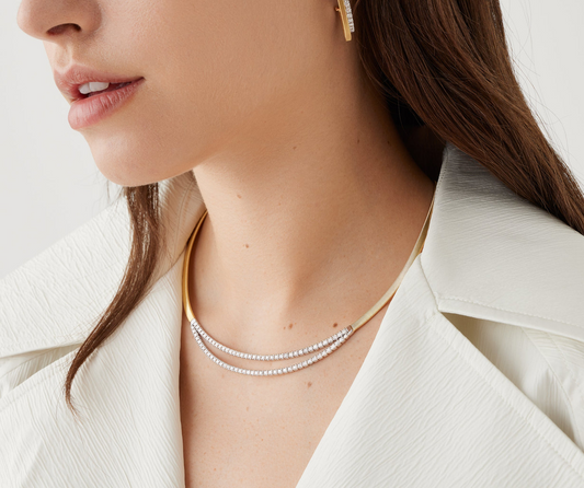 A single 18K yellow gold coil strand, carefully created with the brand's exclusive coil technique and embellished with two brilliant-cut diamond bars. With its sophisticated look, this necklace is a timeless classic granting any outfit a touch of radiance.