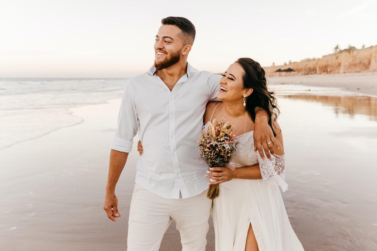 A couple on the shore of the beach after their wedding