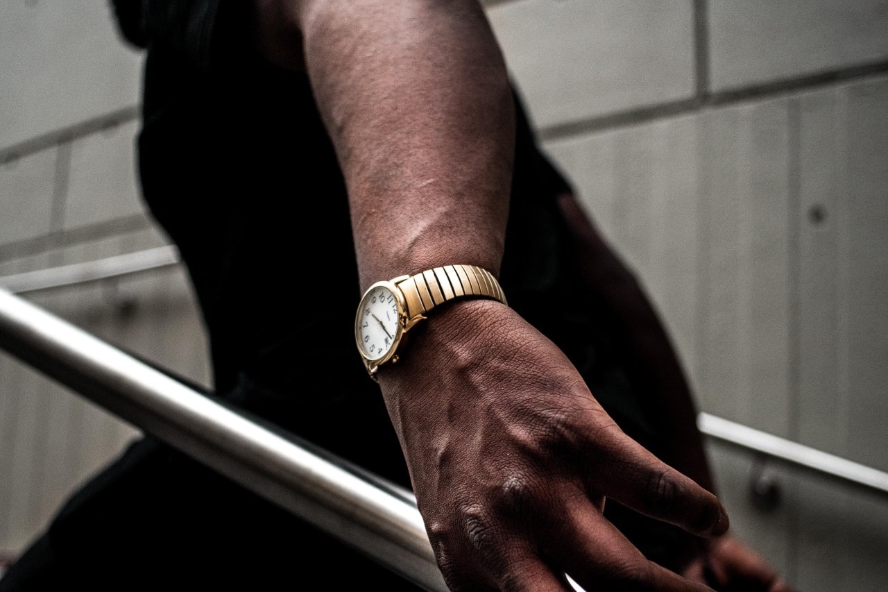a man walking up the stairs, wearing a yellow gold watch