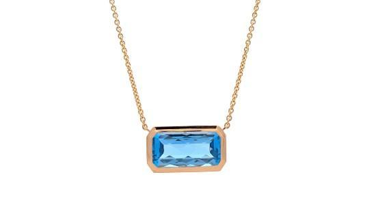 a yellow gold pendant necklace with a rectangular swiss blue topaz center stone