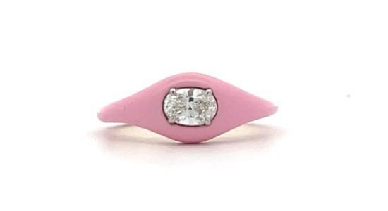 a pink signet shape ring featuring an oval cut center diamond
