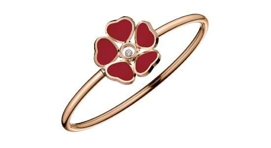 a rose gold bangle bracelet featuring a flower motif made of red hearts