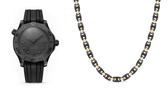 a black ceramic watch next to a chain necklace with black ceramic and gold links