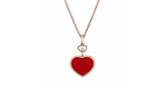 a rose gold necklace featuring a red, heart-shaped pendant and an accent diamond