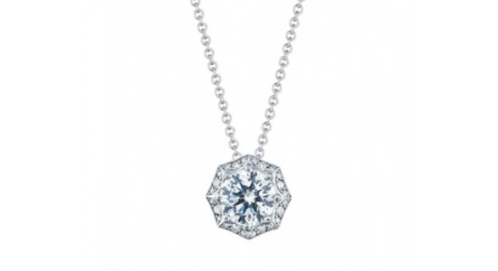 a platinum pendant necklace featuring a round cut diamond and a diamond halo
