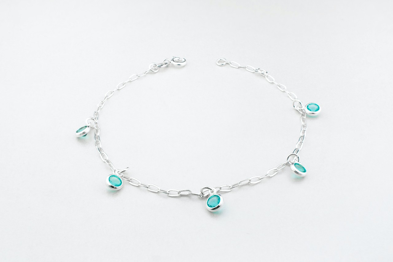 A bracelet with turquoise stations on a white background.